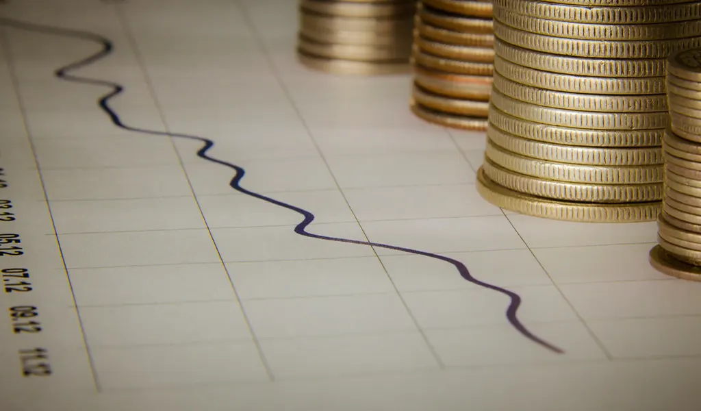 Stacks of coins beside a hand-drawn line on graph paper