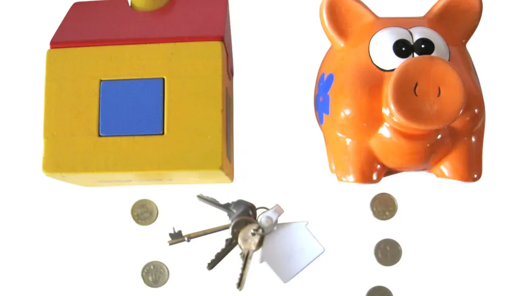 A toy house money box and an orange piggy bank, with house keys and coins between them